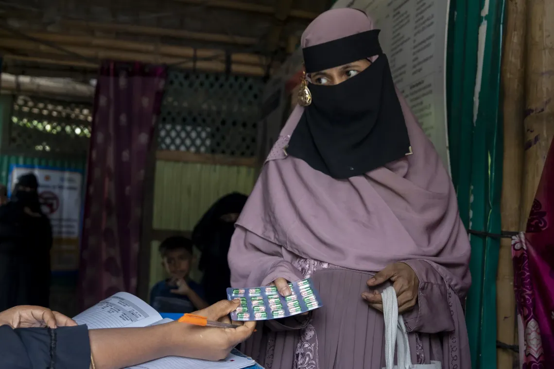 Nur Kayes (22) receives iron and folic acid tablets after a health check-up at the INF.