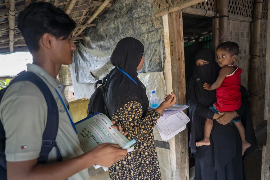 Amin and Tofura visit a household in their assigned block to conduct a routine nutrition screening and follow-up for children. 