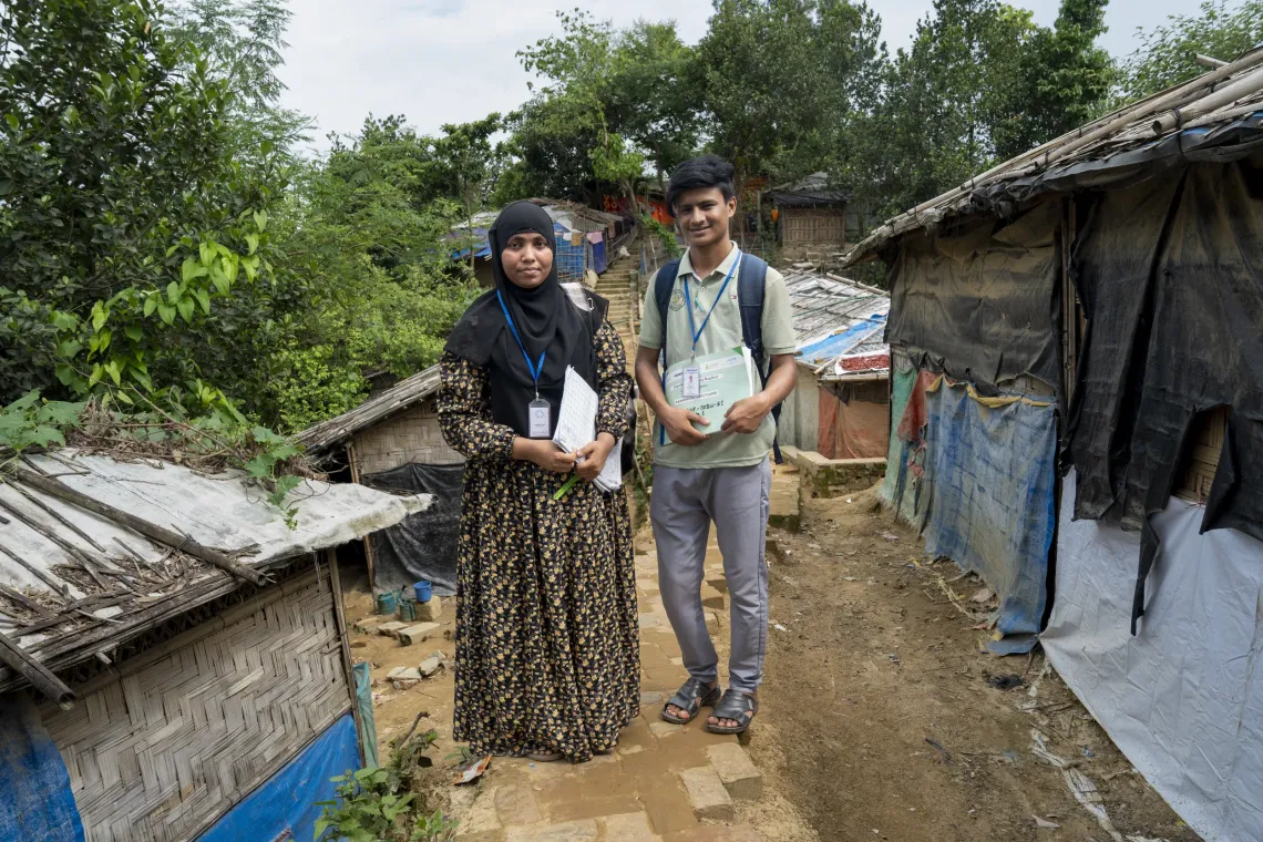 Amin and Tofura walk through the Rohingya refugee camp during their routine household visits.