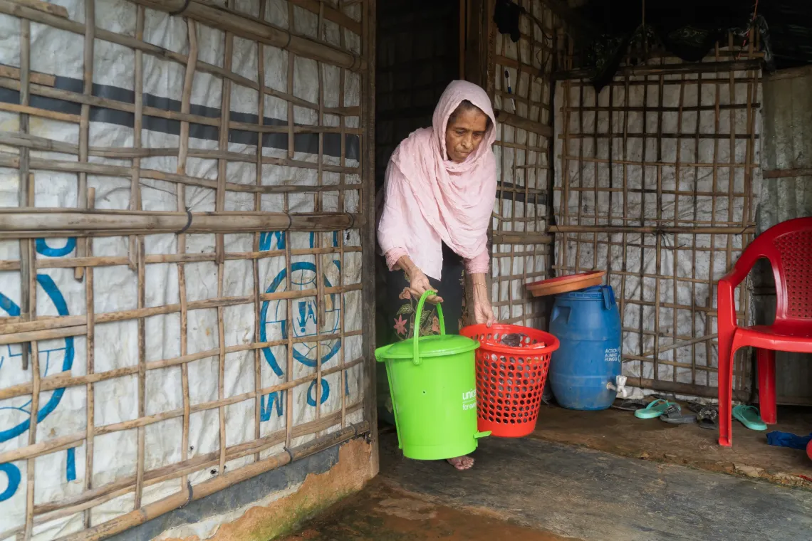 Mustafa Khatun (62), a Rohingya woman leaves waste outside her home for collection.