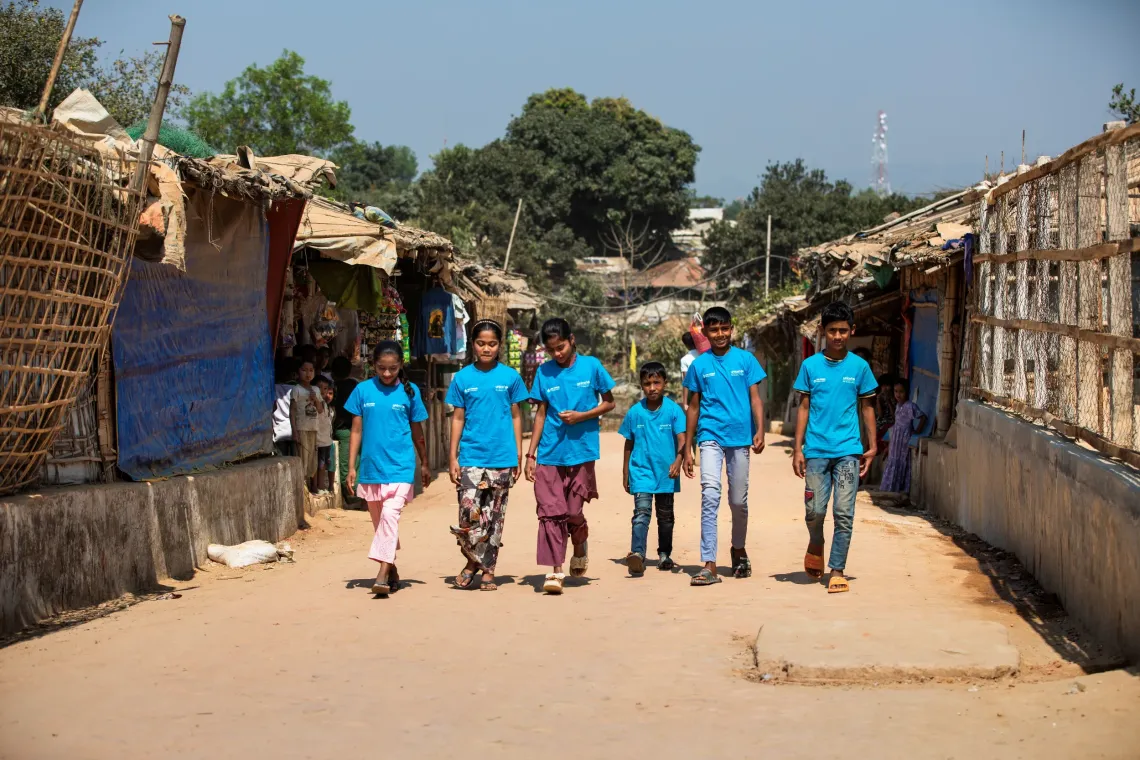 Members of the Child Leaders Group march down the camp street.