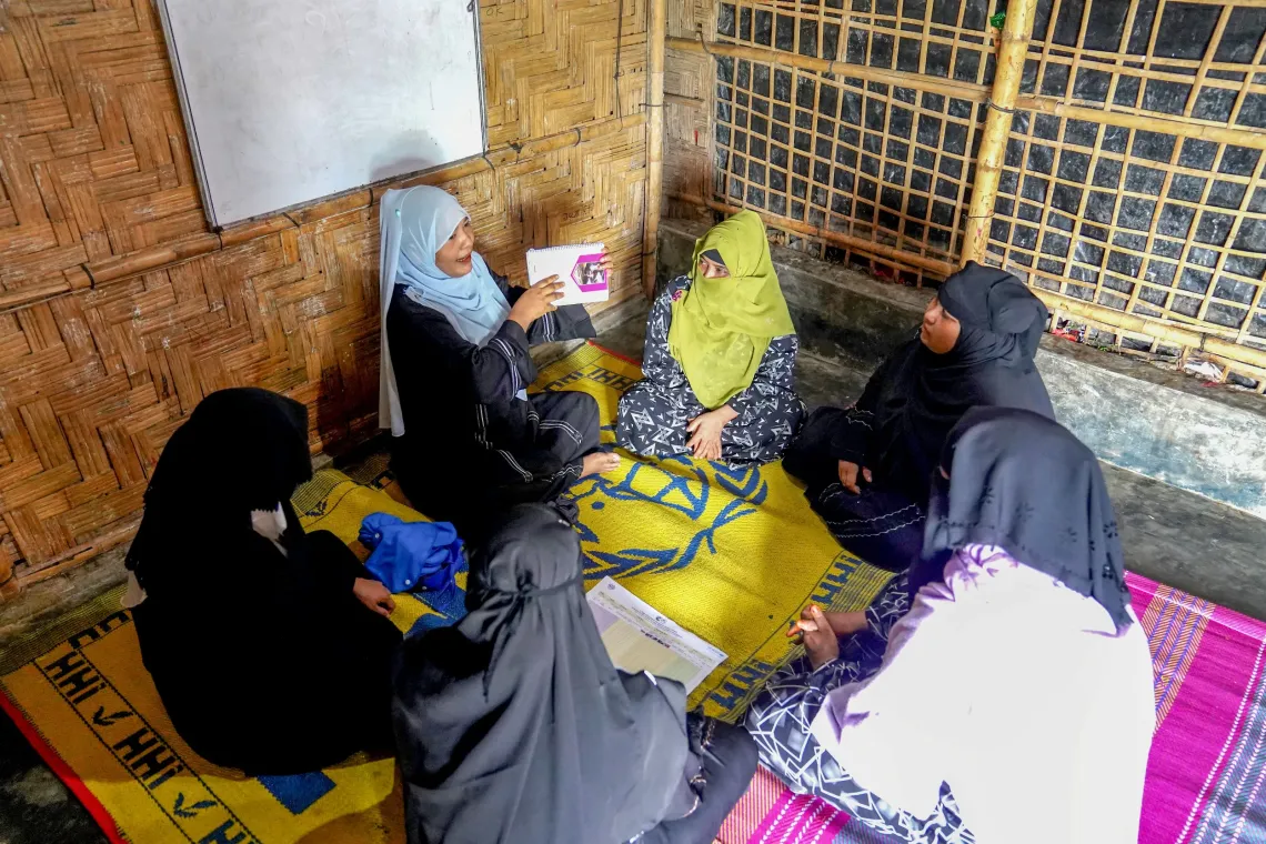 Sabukun (31) discussing about safe management of menstruation with a group of women in a weekly meeting using the &lsquo;Hygiene Management&rsquo; booklet. 