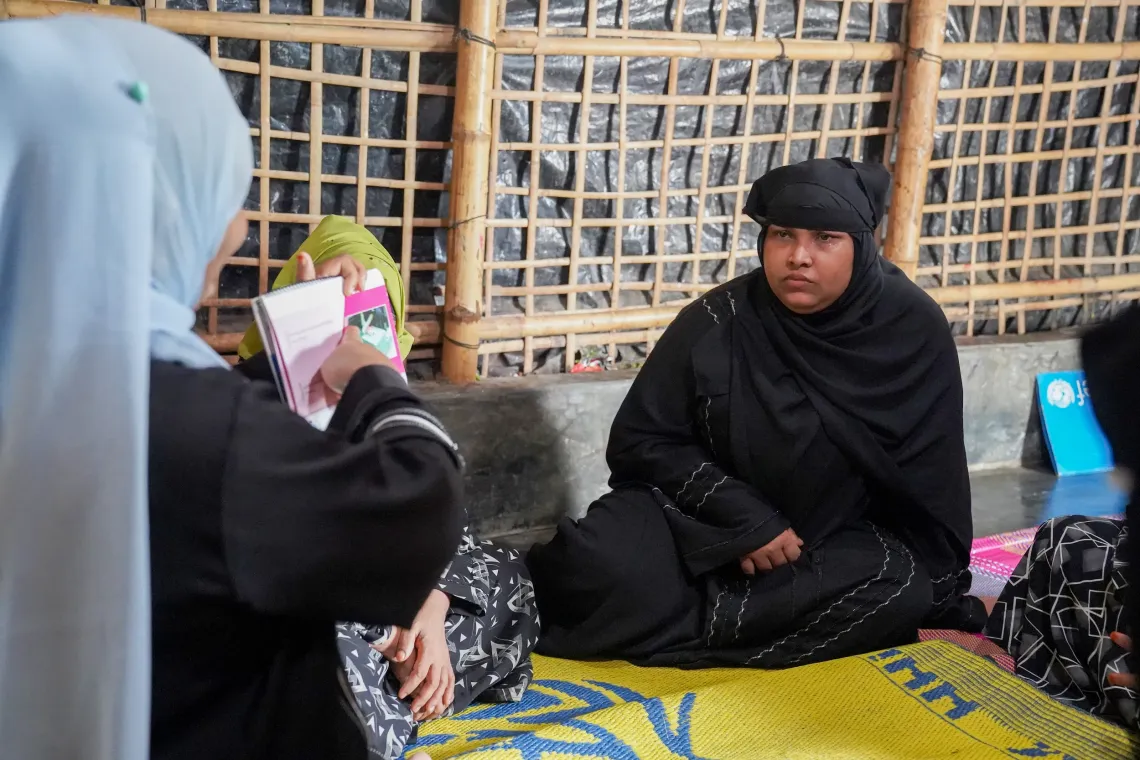 Momtaj Begum (30), Sabukun&rsquo;s neighbor, carefully listening to the instructions provided in hygiene management story booklet. 