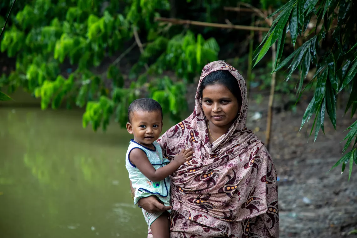 Ayesha Farin with her mother beside a pond near their house.