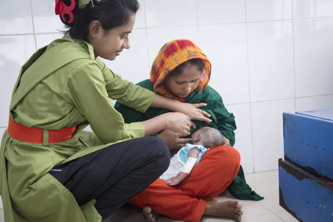 A nurse is helping the breastfeeding mother