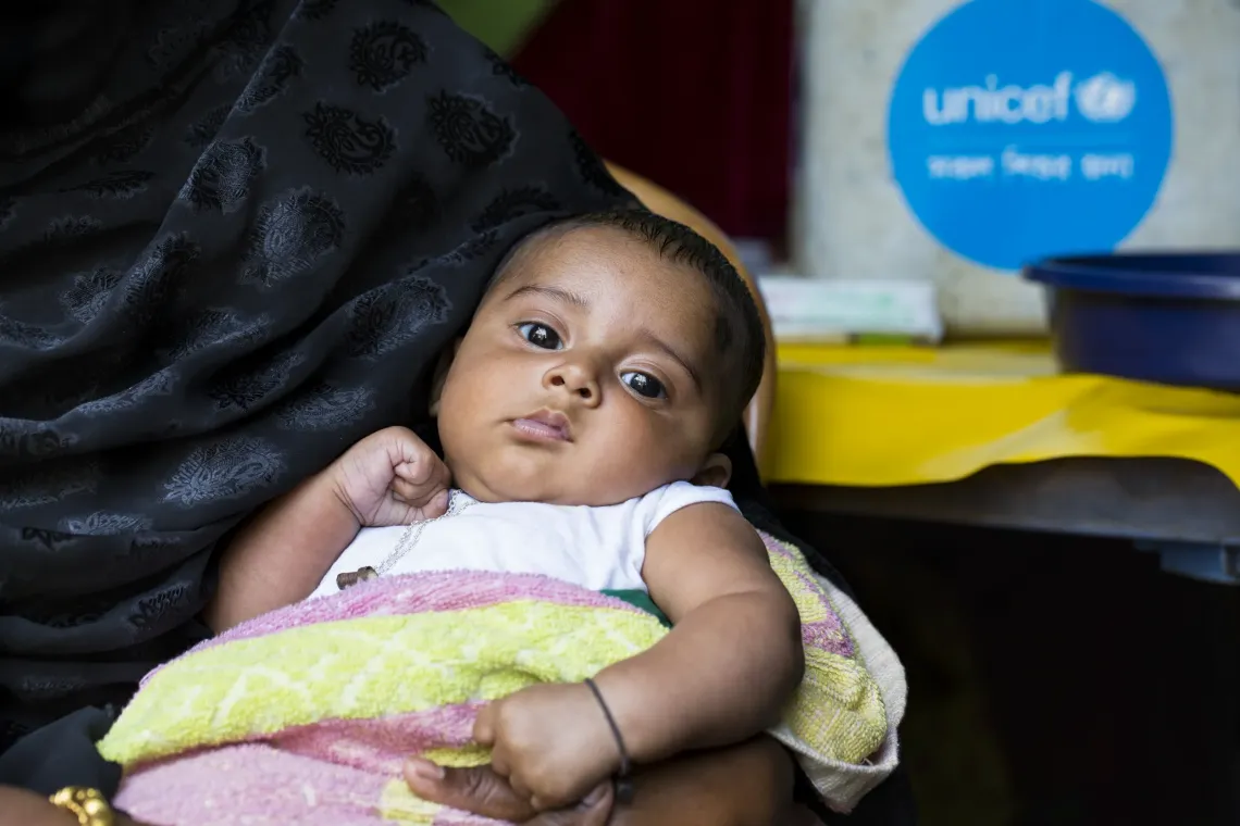 A mother waits in line to get her child vaccinated against measles and rubella (MRV) in Mymensingh.