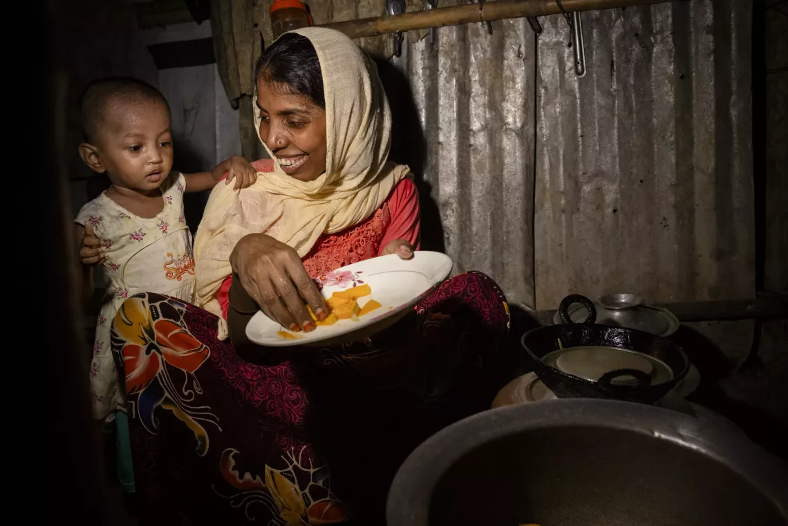Rubeda, 28, prepares a meal for her daughter Sofiba, 2, who suffers from severe acute malnutrition, at their shelter in the Rohingya refugee camps in Cox&rsquo;s Bazar, Bangladesh.