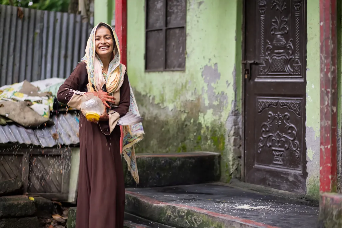 18-year-old Morjina feeds bird feed to pigeons at her home in Cumilla, Bangladesh.