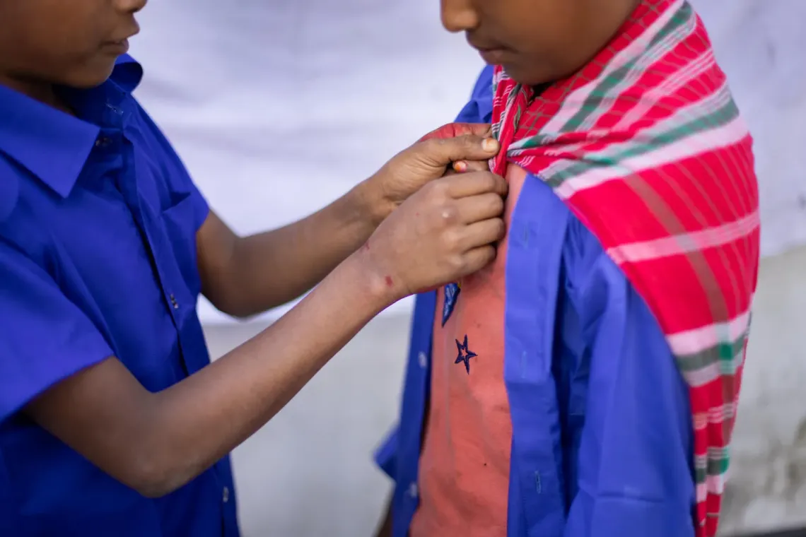12-year-old Riyad helps Abrar tie a cape around his neck to complete his &ldquo;Superman pose&rdquo;. 