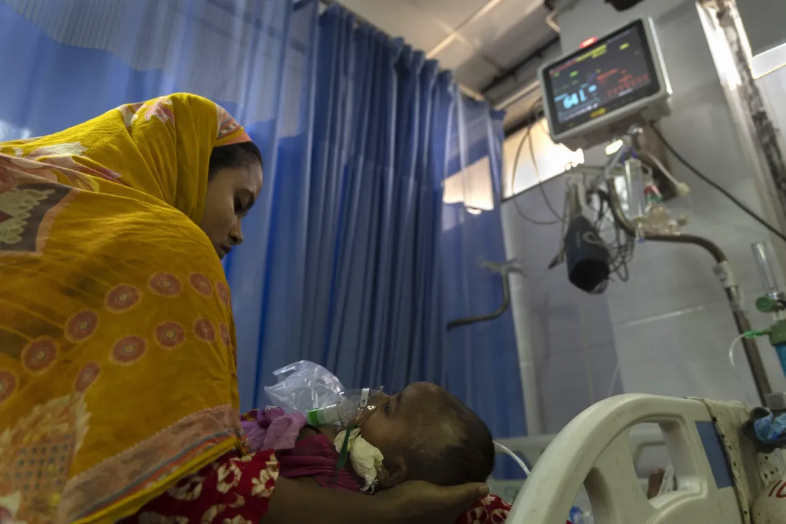 A mother with her child who was diagnosed with measles and needed a nebulizer to treat complications at a hospital in Dhaka
