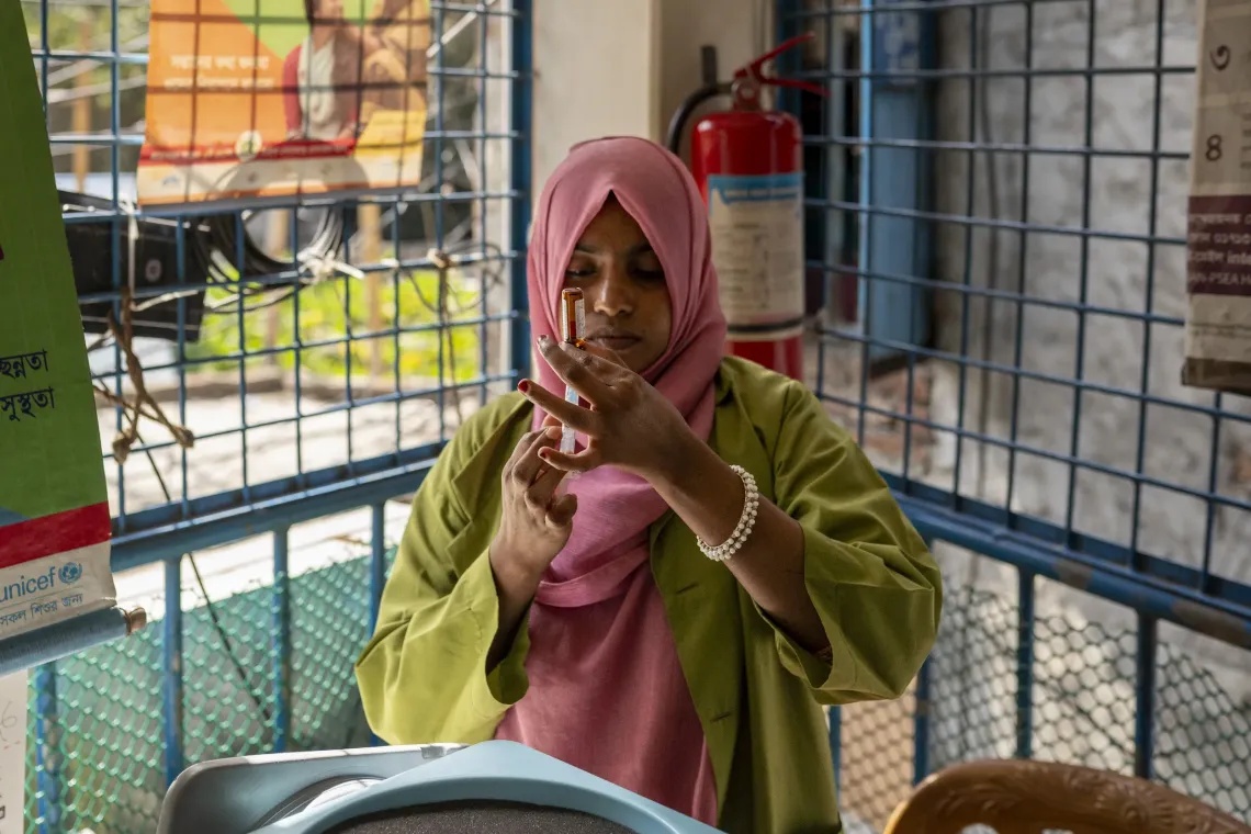 A vaccinator prepares the measles-rubella shot for Ayesha at Alo Clinic, Korail. 