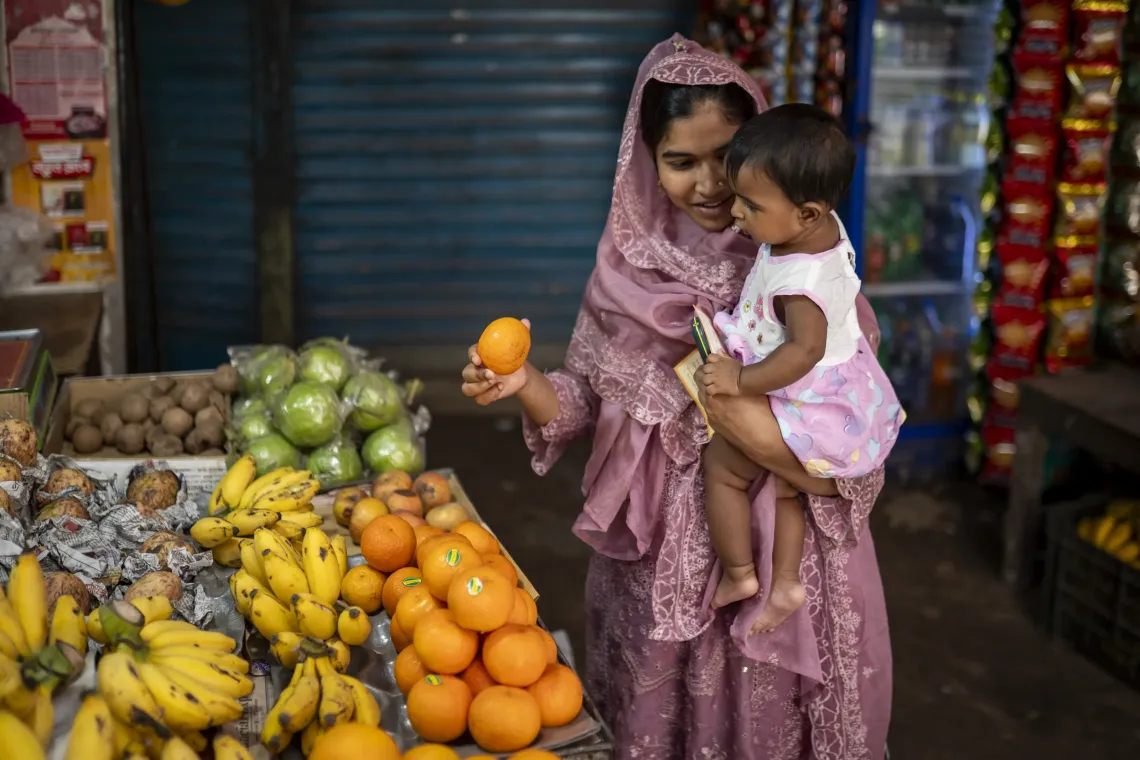 Ayesha, transfixed, at a fruit stall outside Alo Clinic.