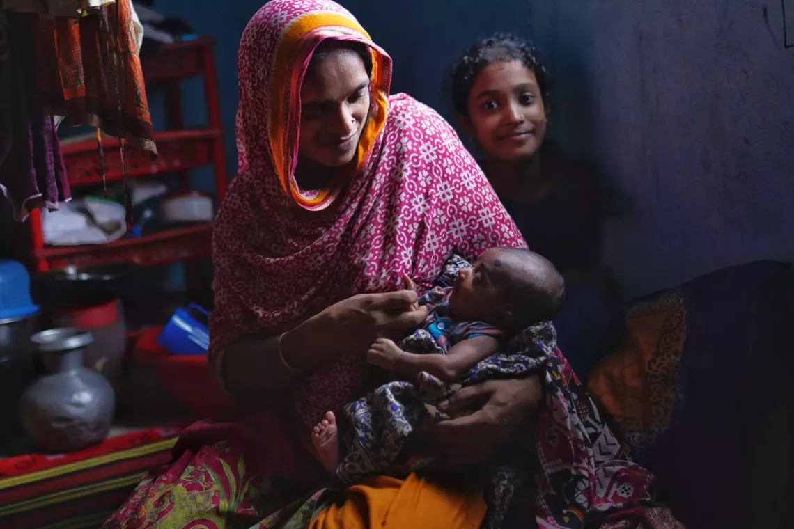 Mohima cradling her two-month-old baby Fatima in her arms