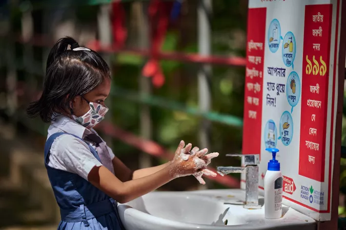 A girl washes her hands in her school's handwashing facility
