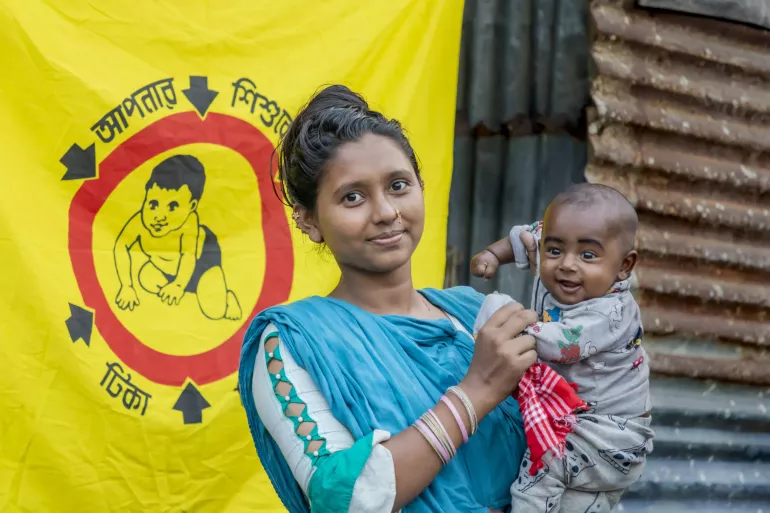 A mother holds her child during a HPV vaccination campaign in Bangladesh.