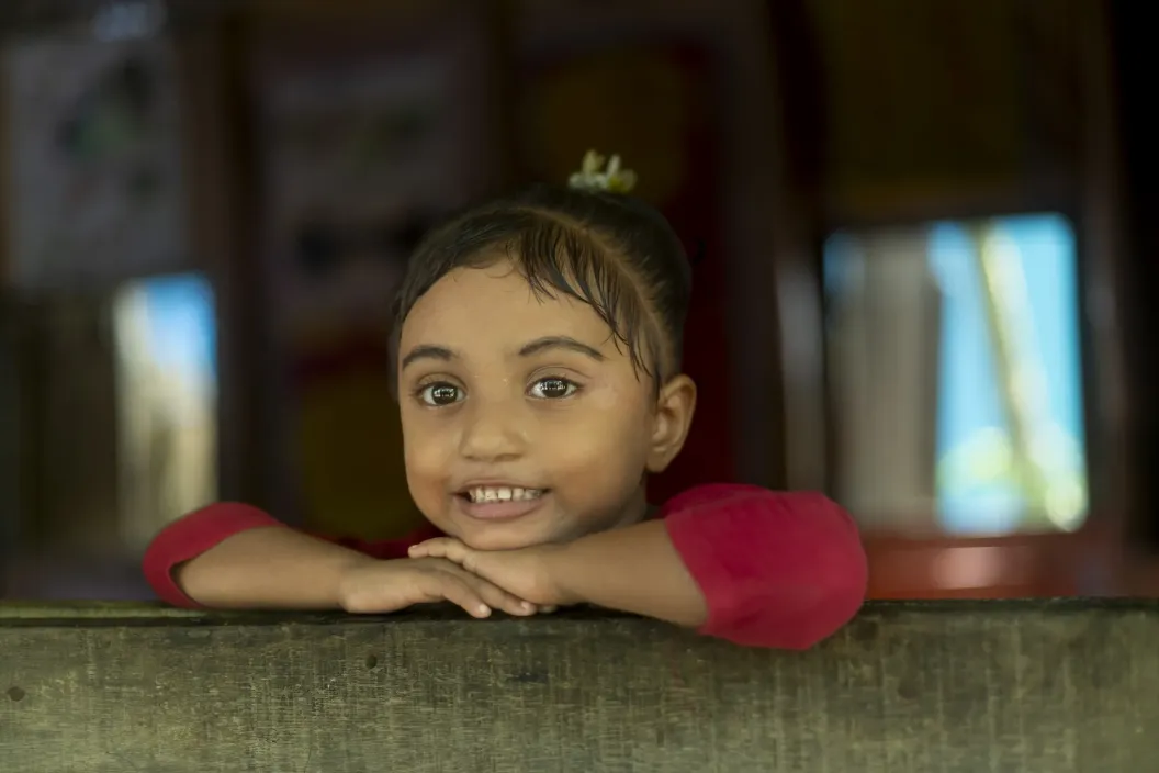 A little girl looks out of a window of Pree Primary Education Learning Center during her class break in Sunamganj, Bangladesh.