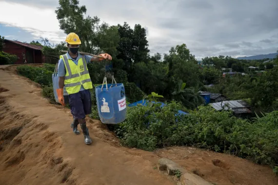 Kamal carries the collected waste to the waste management facility.