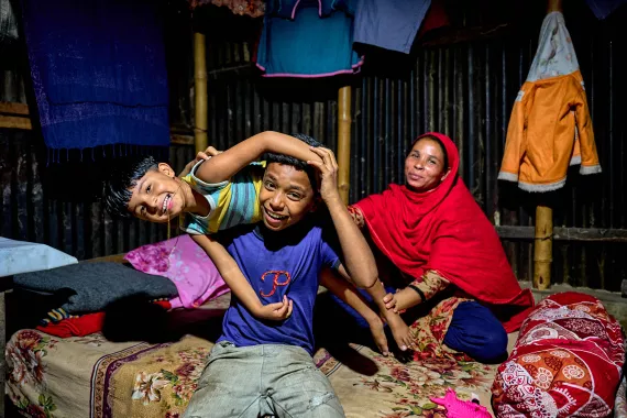 Hasib plays with his younger sister Mim in the slum neighbourhood where they now have a room of their own.