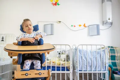 A boy using a standing frame at a baby home