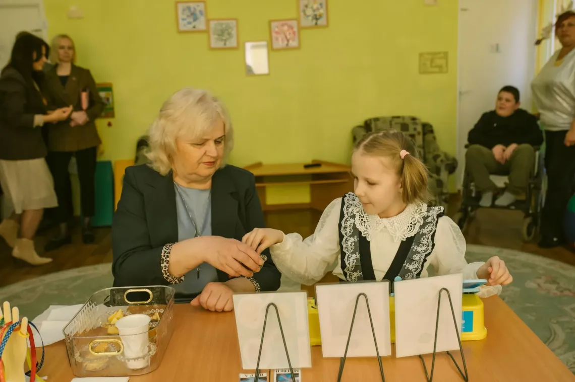 Девочка с педагогом занимается на коммуникаторе
