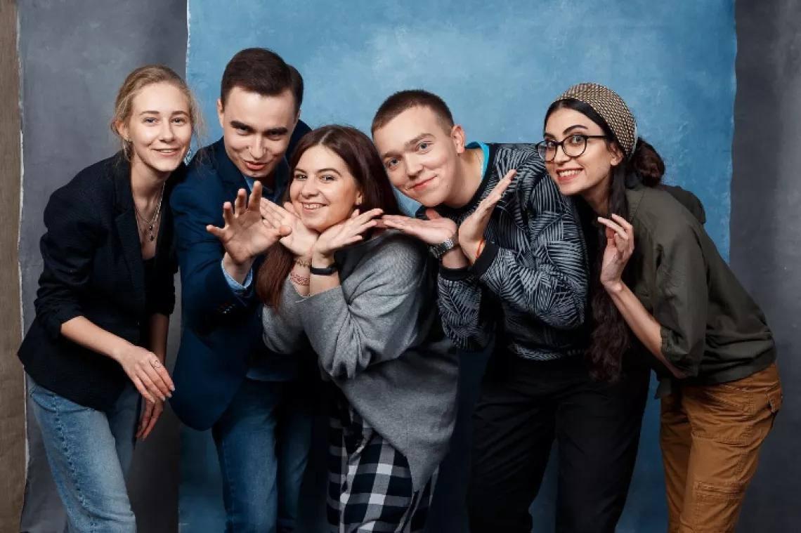 Волонтеры улыбаются, глядя в камеру