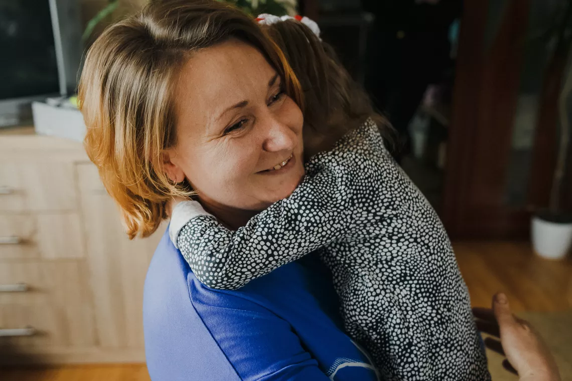 Женшина держит ребенка на руках.