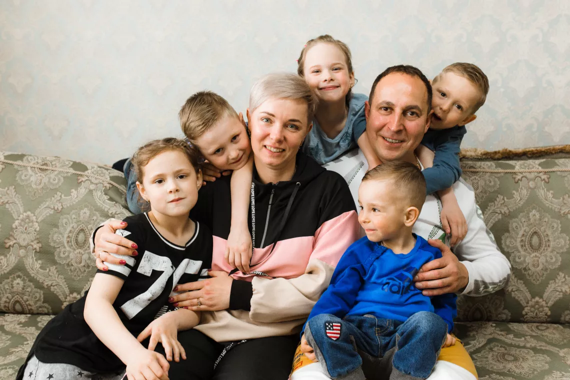 Приемные мама и папа в окружении детей