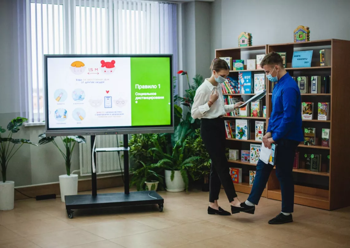 В классе рядом с интерактивной доской двое ребят проводят урок для 5-классников