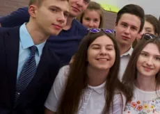 A group of teenagers takes a photograph together