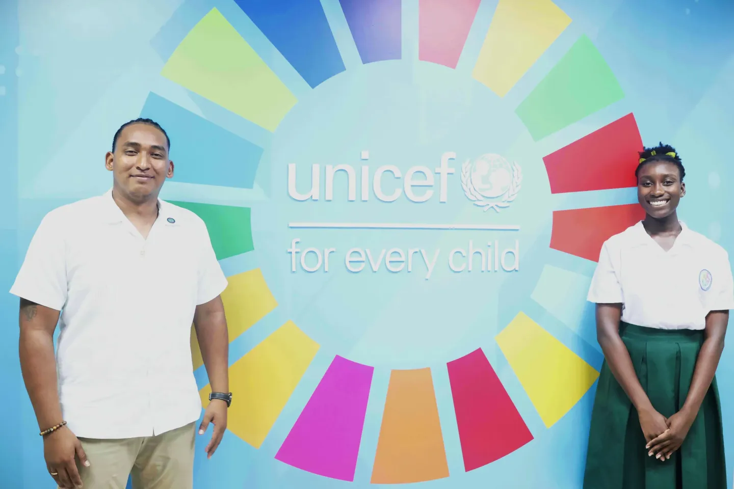 Boy and girl pose infront of UNICEF sign