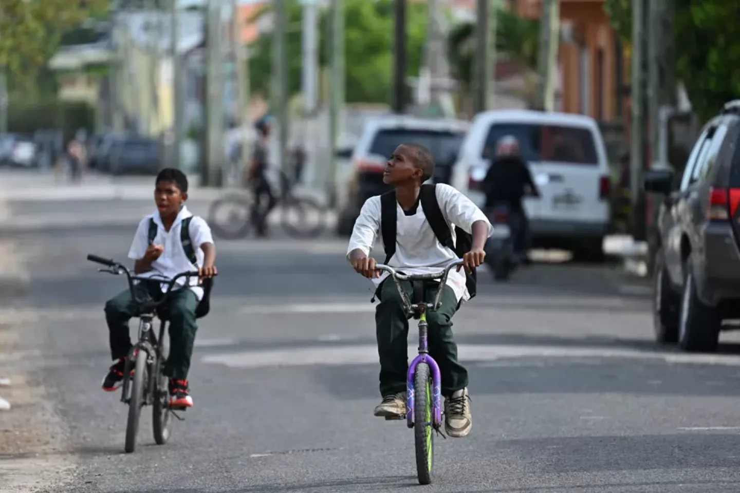 two boys riding in the streets of Belize's southside 