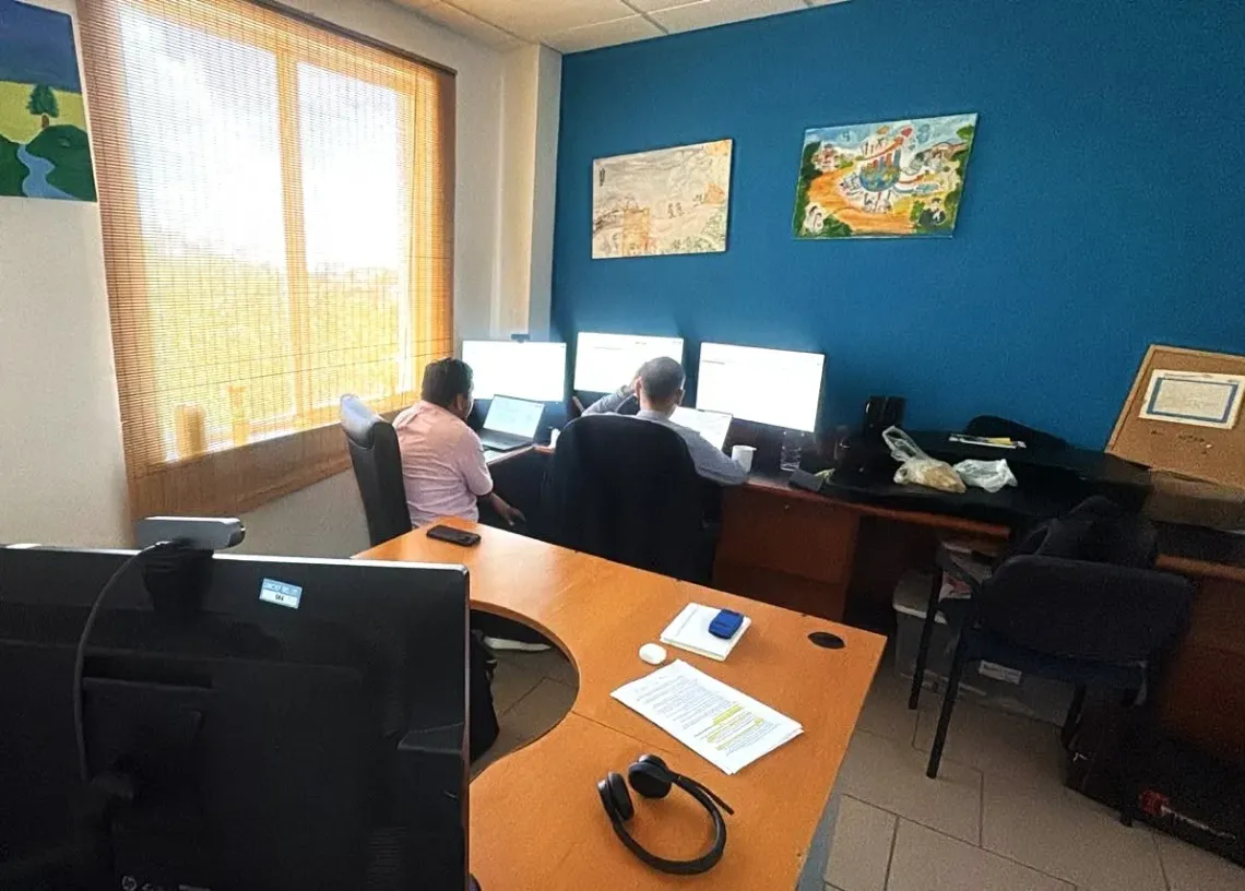 two persons sitting in front of a computer screen