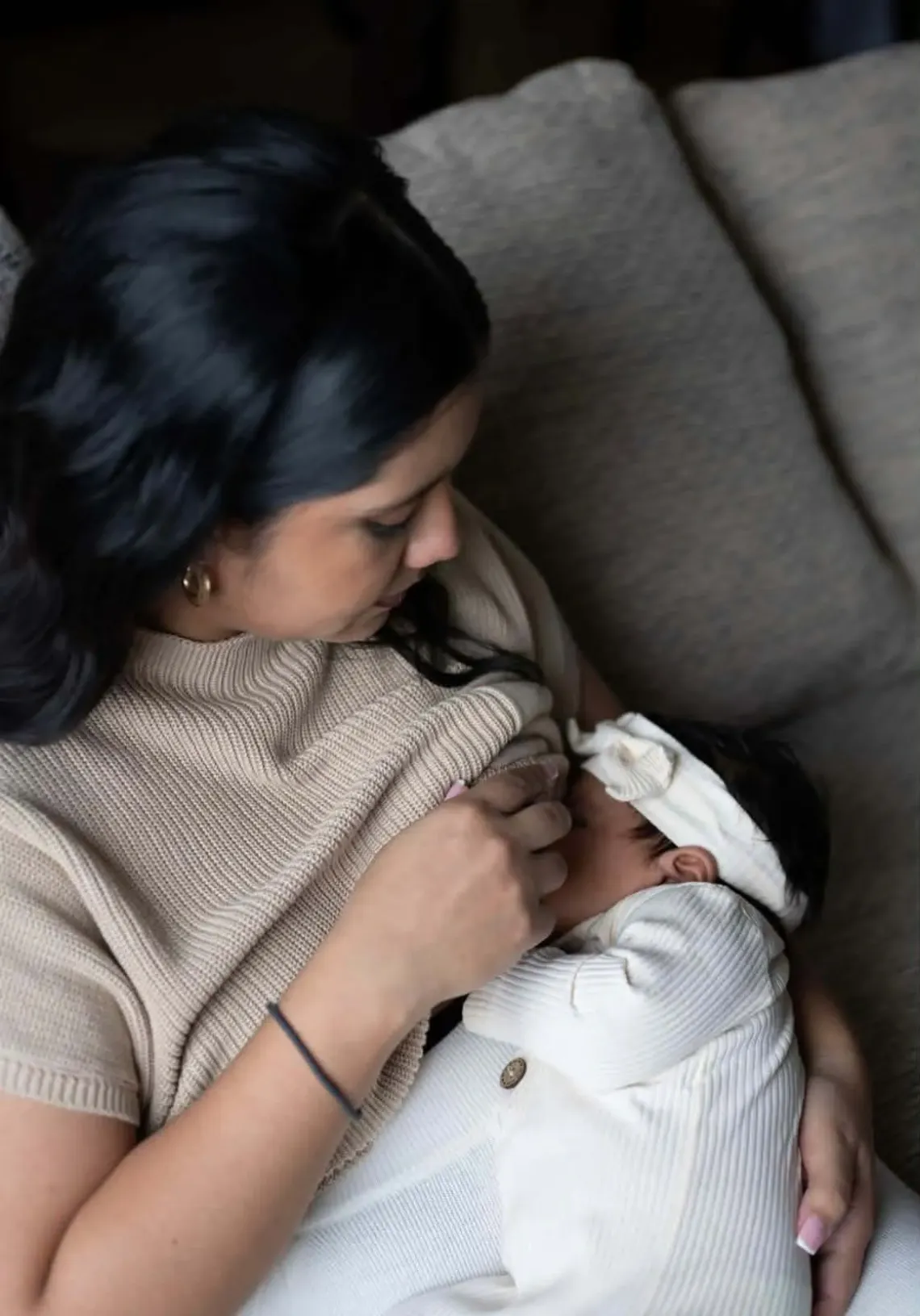 woman sits in chair breastfeeding