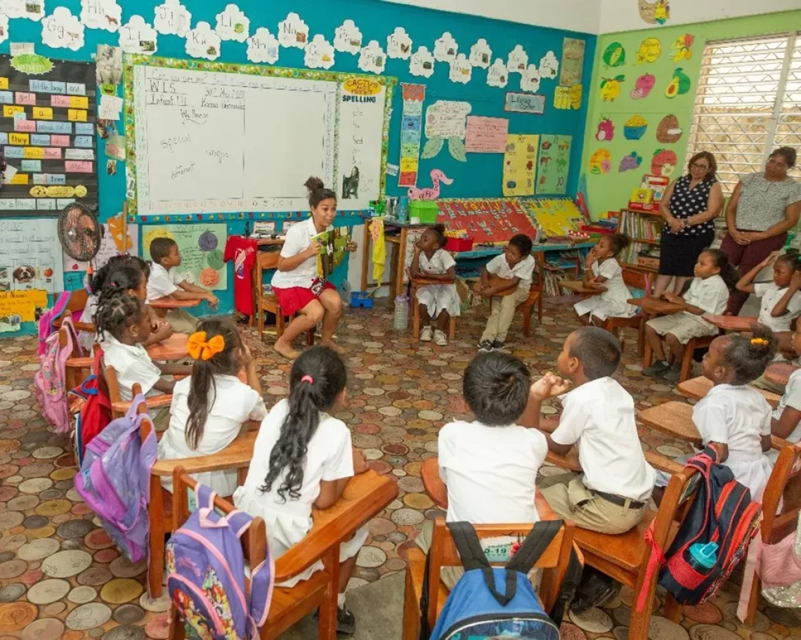 Children sit in cirlce listening to a story