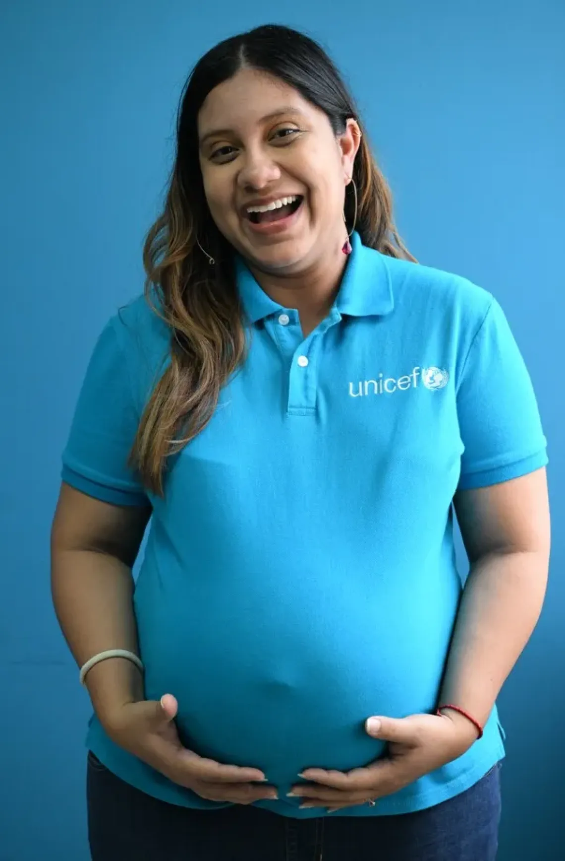 woman stand against wall and holding her belly