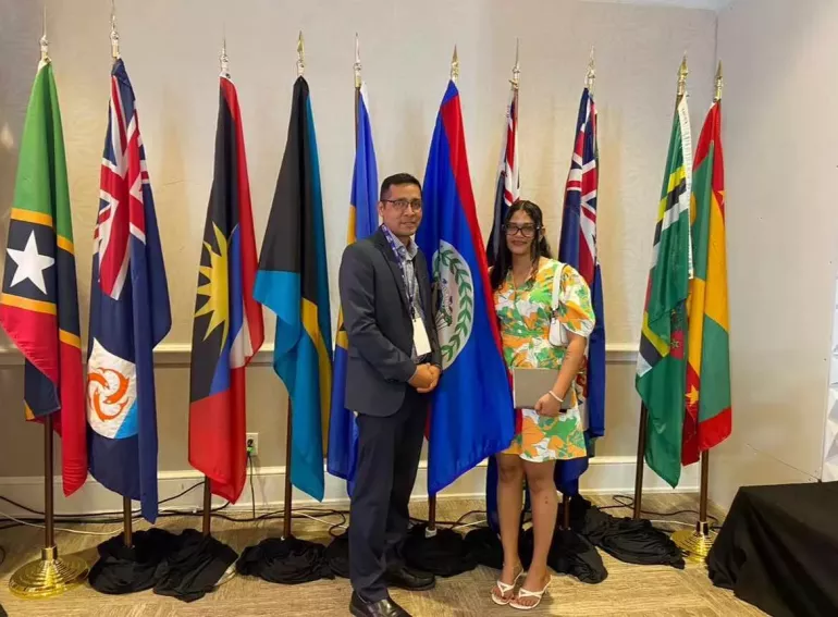 Girl and man stand next to row of flags
