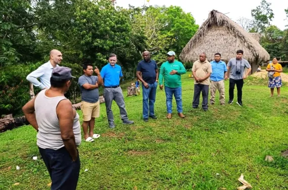 a group of people stand observing the water