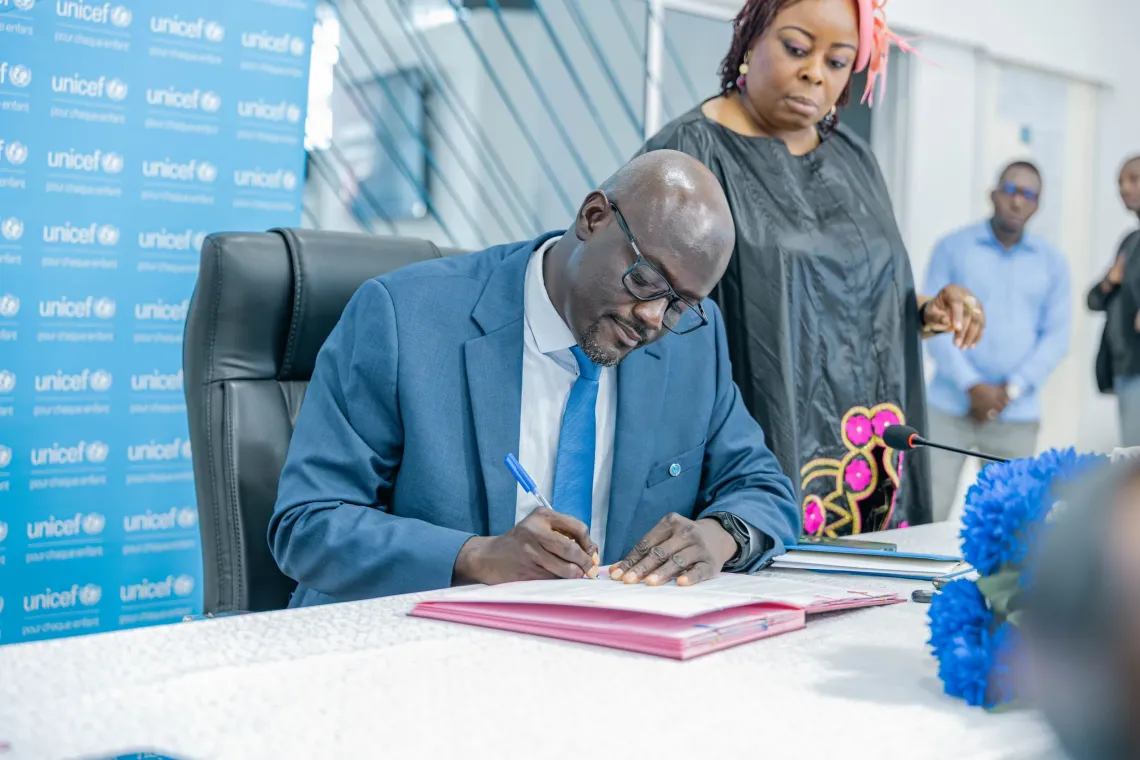 Le Repr&eacute;sentant de l'UNICEF, M. Ousmane Niang, signant le document du partenariat entre l&rsquo;UNICEF et la Mairie de Cotonou.