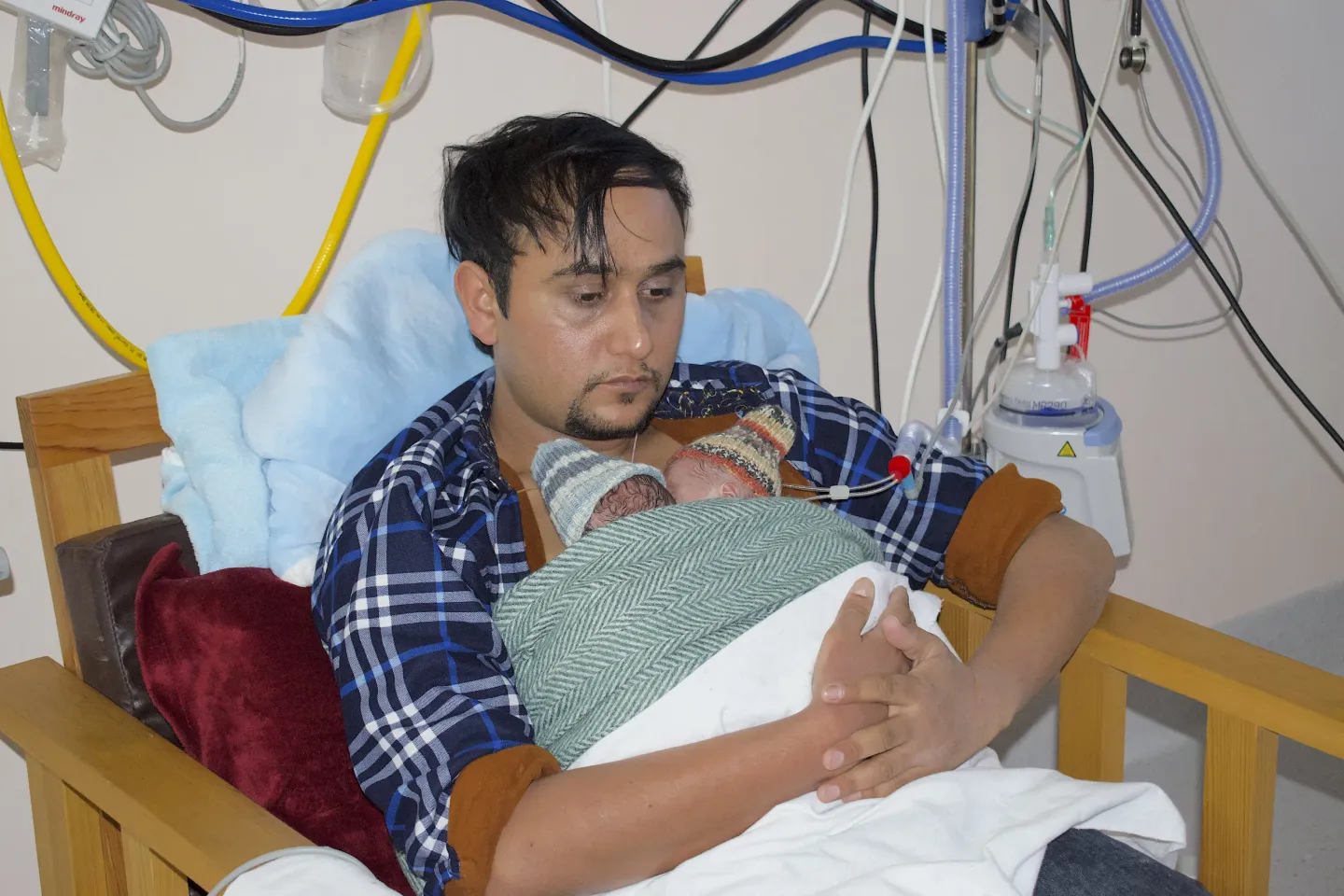 A father provides skin to skin contact to his pre-term babies