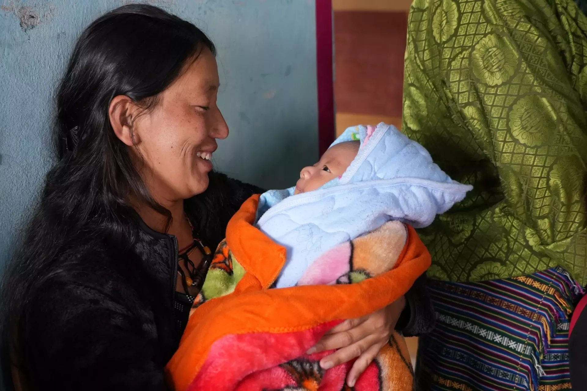 A mother smiles at her newborn 