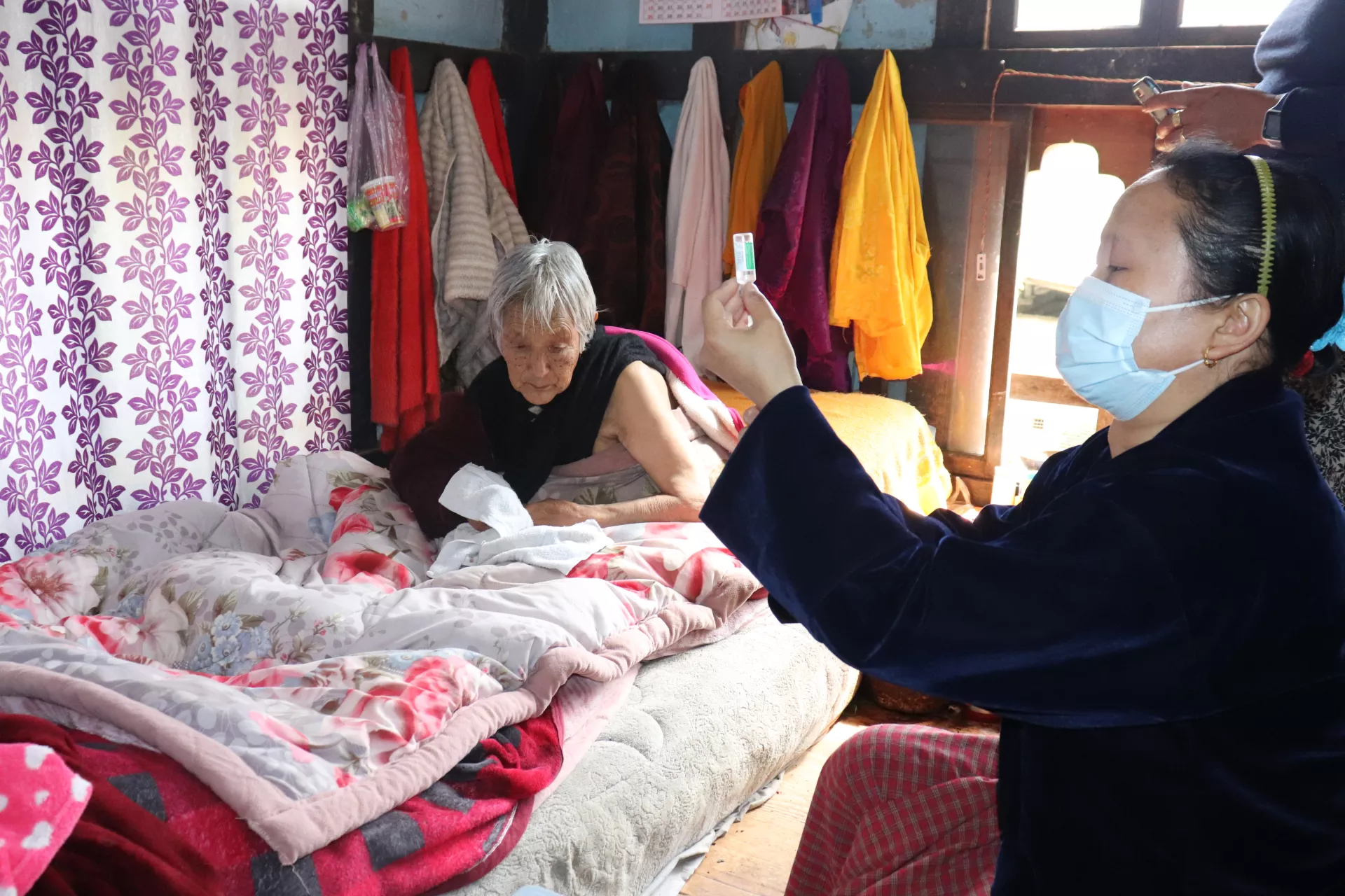 A nurse readies a vaccine during a home visit in Wangdue