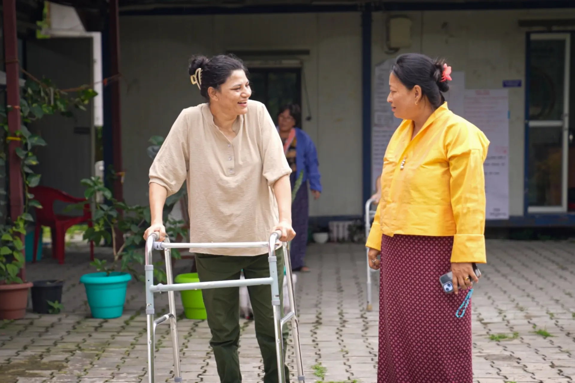 A woman with a walker interacts with a woman in kira 