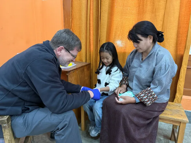 Dr. Philip testing the blood lead levels of Kinley Zam and her daughter Sonam Tshoki,4. 
