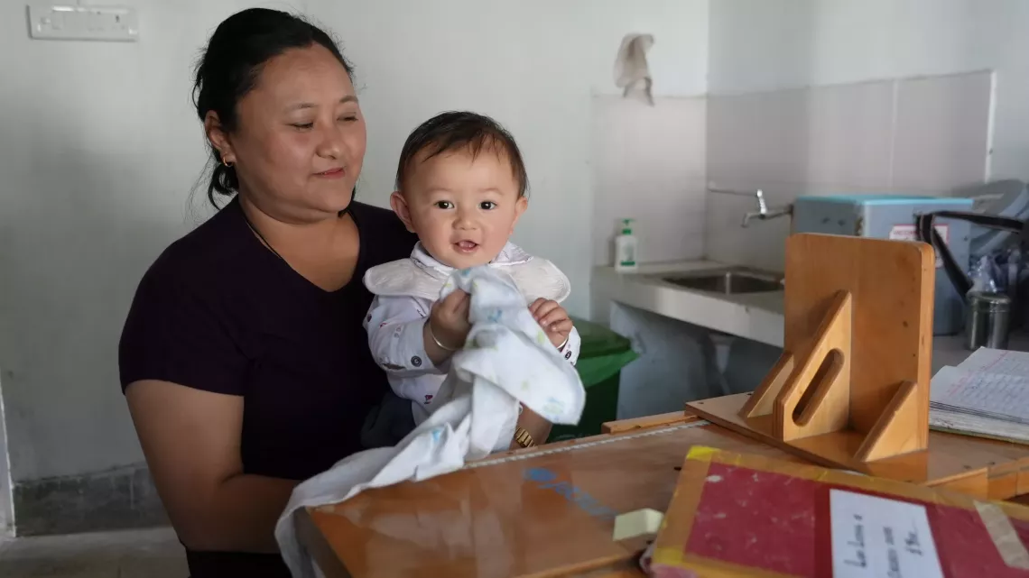 Bina Ghalley with her youngest child at Norbugang Primary Health Center in Samtse district. 