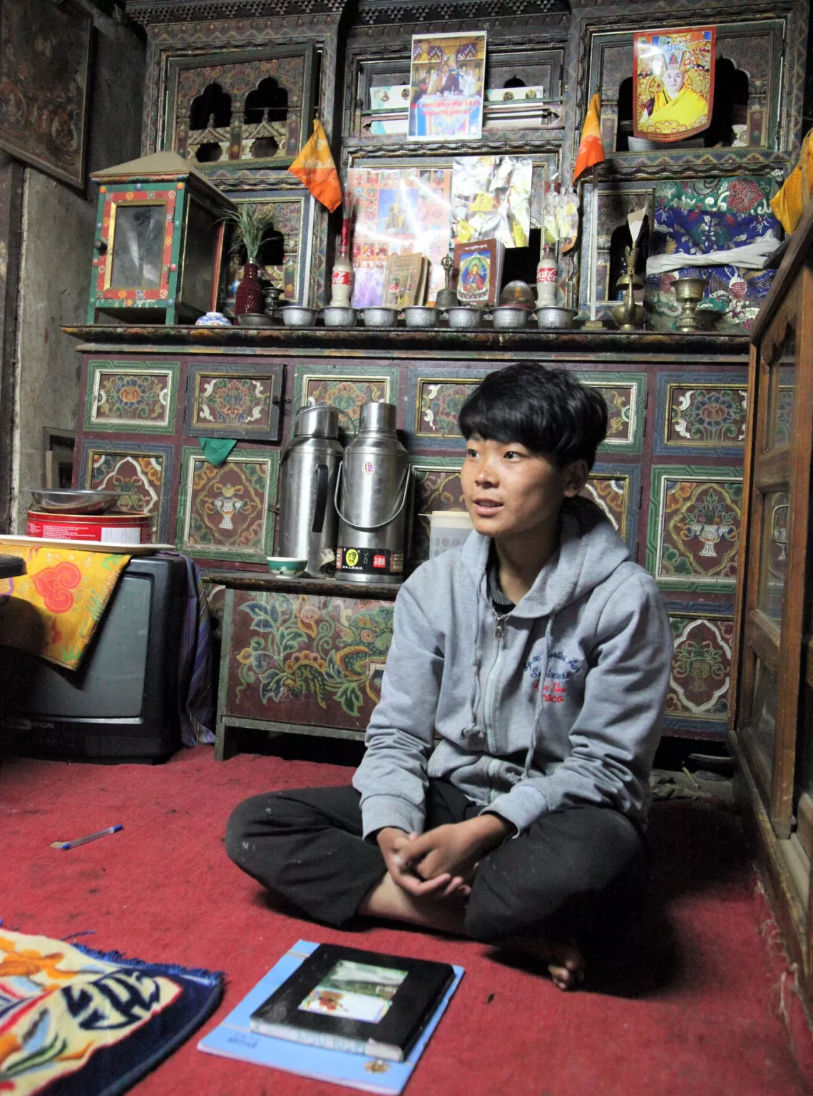 A teenager in her altar room with her books