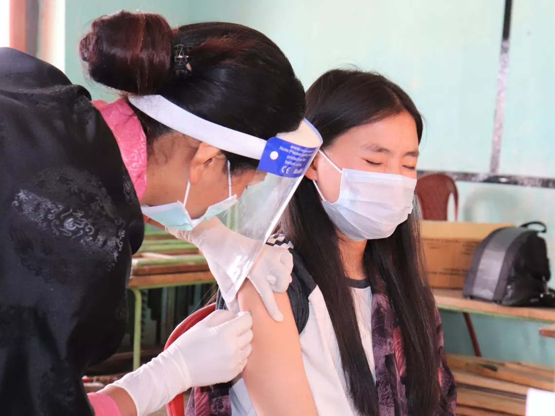 A young girl gets her dose of COVID-19 vaccine in Dagana