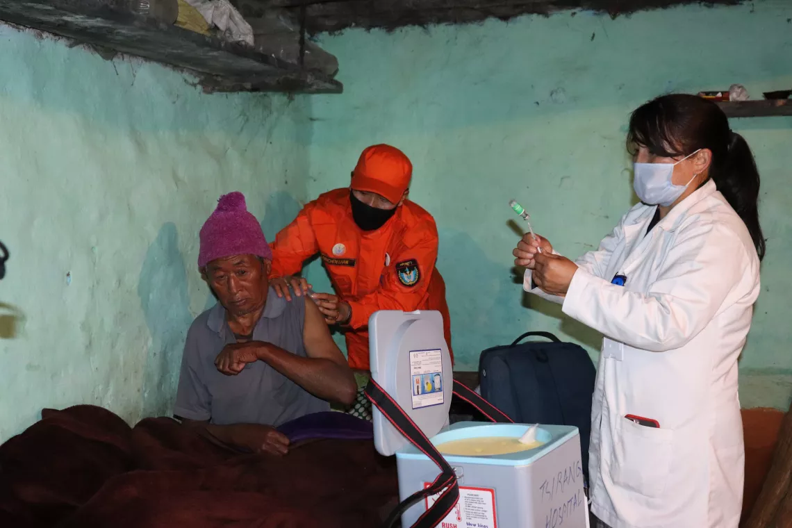 An old man gets vaccinated at home