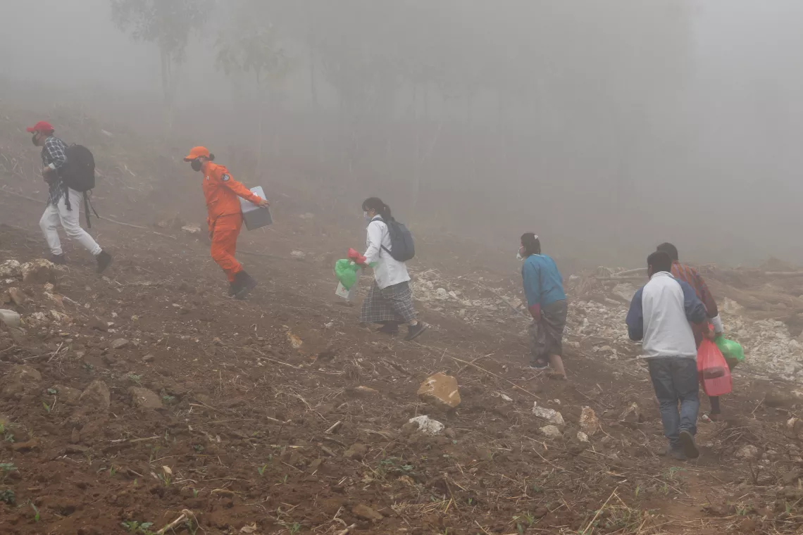 A group of people walk through the fields