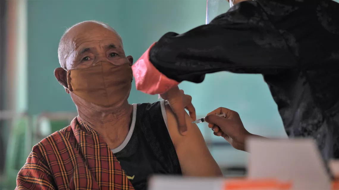 An elderly man receives his dose of COVID-19 vaccine