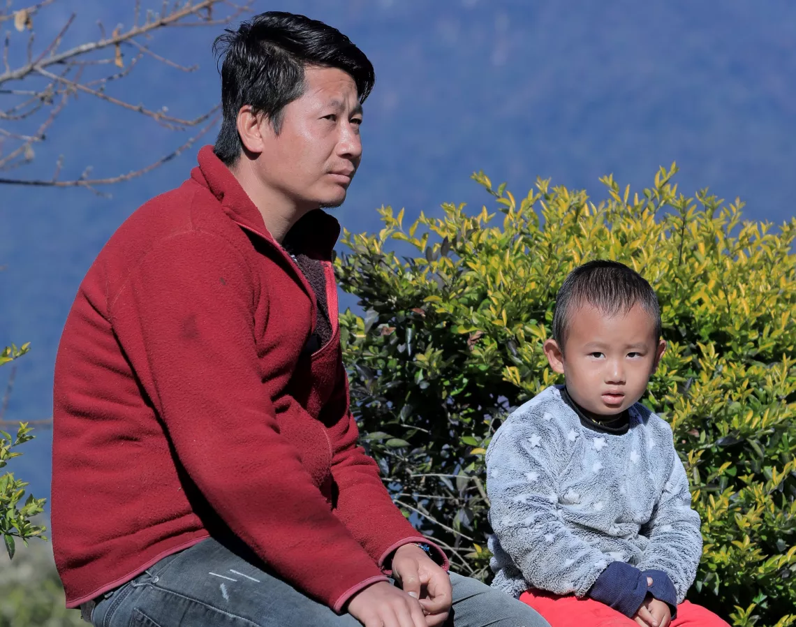 A man and a child sitting on a bench